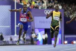 Noah Lyles (trái) cán đích đầu tiên ở chung kết chạy 100m nam trong sân Stade de France, tại Olympic Paris, Pháp tối 4/8/2024. Ảnh: AP